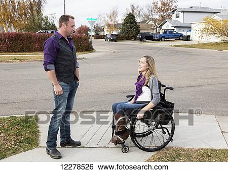 Stock Photograph - Husband and wife with disability spending time together outdoors; Spruce Grove, Alberta, Canada. Fotosearch