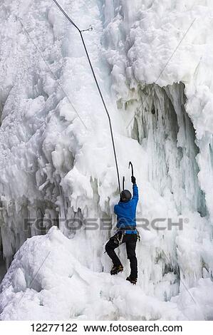 Ice climber with ice pick climbing frozen cliff face; Banff, Alberta, Canada View Large Photo Image Stock Image - Ice climber with ice pick climbing frozen cliff face; Banff, Alberta, Canada. Fotosearch