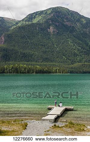 Stock Image - Mother and daughter on a dock at Muncho Lake Provincial Park, British Columbia, Canada, Summer. Fotosearch