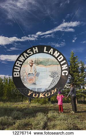 Picture - Mother and daughter viewing roadside for Burwash Landing, Yukon Territory, Canada, Summer. Fotosearch