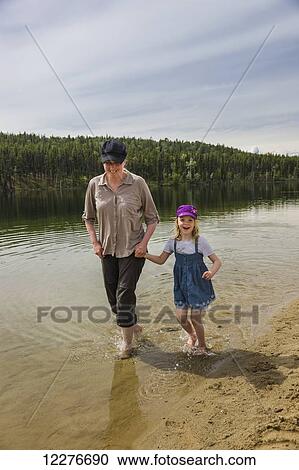 Mother and daughter wade with bare feet in Lucky Lake, Yukon Territory, Canada, Summer View Large Photo Image Stock Image - Mother and daughter wade with bare feet in Lucky Lake, Yukon Territory, Canada, Summer. Fotosearch