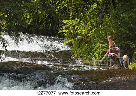 Stock Photo - Mother with boy and girl beside small waterfalls, Zomba plateau; Malawi. Fotosearch