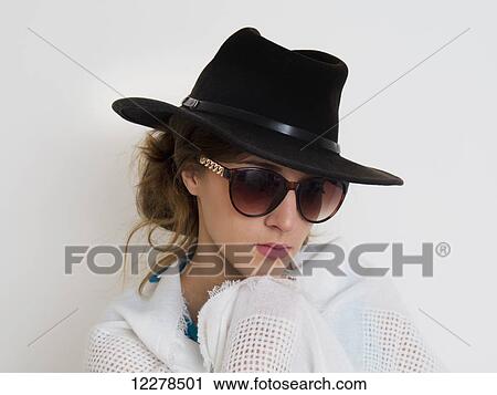 Portrait of a girl wearing a black hat and sunglasses; England View Large Photo Image Stock Image - Portrait of a girl wearing a black hat and sunglasses; England. Fotosearch
