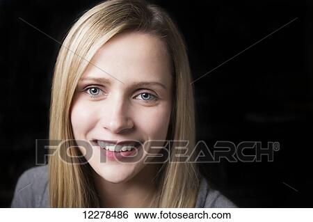 Stock Photograph - Portrait of beautiful young woman on a black background; Spruce Grove, Alberta, Canada. Fotosearch