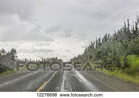 Stock Photo - Rain on a vehicle window while on the Alaska Highway north of Watson Lake, Yukon Territory, Canada, Summer. Fotosearch