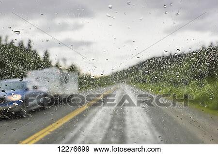 Stock Photo - Rain on a vehicle window while on the Alaska Highway north of Watson Lake, Yukon Territory, Canada, Summer. Fotosearch