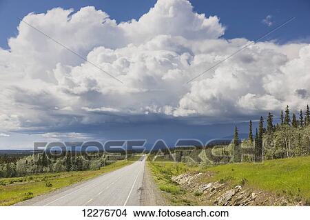 Scenic view of the Alaska Highway near Whitehorse with rain clouds in the distance, Yukon Territory, Canada, Summer View Large Photo Image Picture - Scenic view of the Alaska Highway near Whitehorse with rain clouds in the distance, Yukon Territory, Canada, Summer. Fotosearch