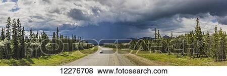Stock Photo - Scenic view of the Alaska Highway near Whitehorse with rain clouds in the distance, Yukon Territory, Canada, Summer. Fotosearch