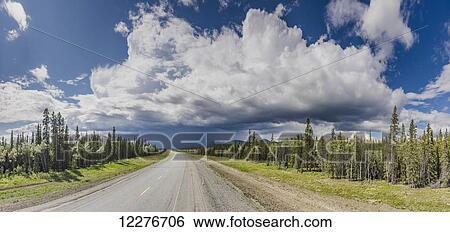 Stock Photograph - Scenic view of the Alaska Highway near Whitehorse with rain clouds in the distance, Yukon Territory, Canada, Summer. Fotosearch