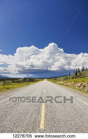 Stock Photography - Scenic view of the Alaska Highway near Whitehorse with rain clouds in the distance, Yukon Territory, Canada, Summer. Fotosearch