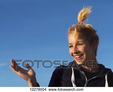 Teenage girl laughing against a blue sky; England View Large Photo Image Picture - Teenage girl laughing against a blue sky; England. Fotosearch