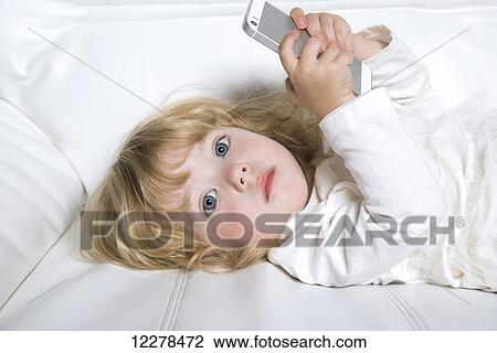 Stock Image - Toddler playing with a smart phone; Spruce Grove, Alberta, Canada. Fotosearch