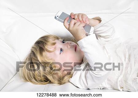 Toddler playing with a smart phone; Spruce Grove, Alberta, Canada View Large Photo Image Stock Photo - Toddler playing with a smart phone; Spruce Grove, Alberta, Canada. Fotosearch