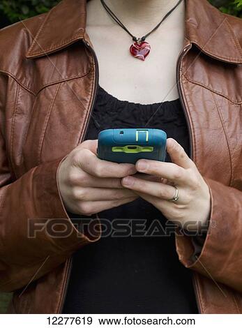 Stock Photo - Woman using her smart phone; Surrey, British Columbia, Canada. Fotosearch