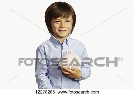 Stock Photography - Young boy holding ceramic piggy bank; Montreal, Quebec, Canada. Fotosearch