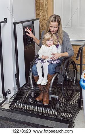Young disabled mother with her daughter using wheelchair powered device to assist with mobility; Spruce Grove, Alberta, Canada View Large Photo Image Stock Image - Young disabled mother with her daughter using wheelchair powered device to assist with mobility; Spruce Grove, Alberta, Canada. Fotosearch
