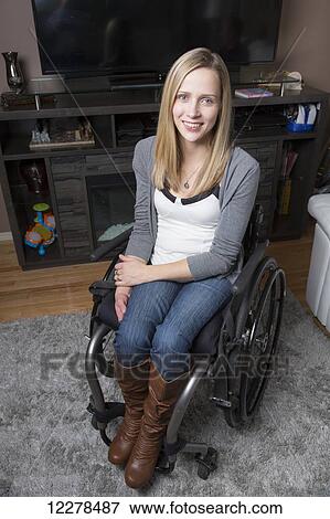 Young disabled woman in a wheelchair in her living room; Spruce Grove, Alberta, Canada View Large Photo Image Stock Photo - Young disabled woman in a wheelchair in her living room; Spruce Grove, Alberta, Canada. Fotosearch