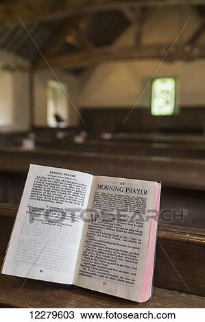 Stock Image - A book open to a morning pray inside a church; Northumberland, England. Fotosearch
