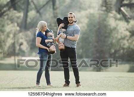 Stock Photograph - A family with young children playing in a park; Edmonton, Alberta, Canada. Fotosearch