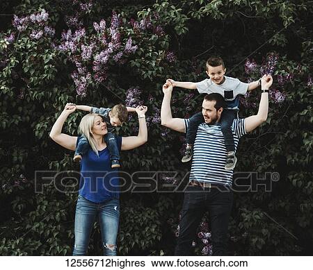 Stock Photograph - A family with young children playing in a park; Edmonton, Alberta, Canada. Fotosearch