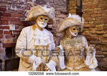 A man and woman dressed in gold and white costumes and masks; Venice, Italy View Large Photo Image Stock Photo - A man and woman dressed in gold and white costumes and masks; Venice, Italy. Fotosearch