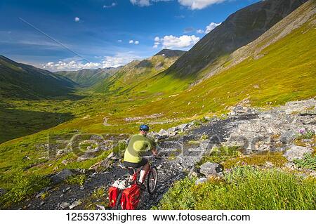 A man riding his mountain bike on the Palmer Valley Road near Hope, Alaska on a sunny summer day in South-central Alaska; Alaska, United States of America View Large Photo Image Stock Photograph - A man riding his mountain bike on the Palmer Valley Road near Hope, Alaska on a sunny summer day in South-central Alaska; Alaska, United States of America. Fotosearch