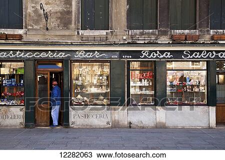 Stock Image - A man standing in the doorway of a retail store; Venice, Italy. Fotosearch