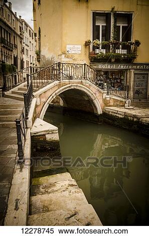 Stock Photography - A pedestrian bridge crosses the canal; Venice, Italy. Fotosearch