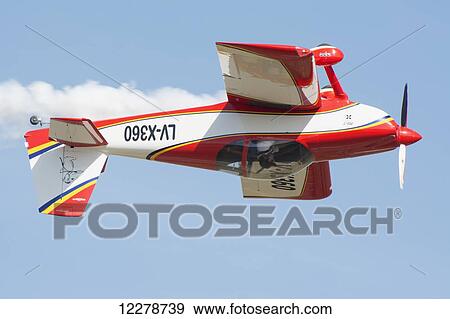 Stock Photo - A red and white sport aircraft in inverted flight; Rivadavia, Mendoza, Argentina. Fotosearch