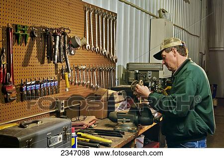 Agriculture - A farmer works on machinery in his farm workshop / Iowa, USA. View Large Photo Image Stock Photo - Agriculture - A farmer works on machinery in his farm workshop / Iowa, USA.. Fotosearch