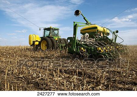 Agriculture - A tractor and planter planting no-till corn in spring in a field of corn stubble and residue / near Blue Earth, Minnesota, USA. View Large Photo Image Stock Photo - Agriculture - A tractor and planter planting no-till corn in spring in a field of corn stubble and residue / near Blue Earth, Minnesota, USA.. Fotosearch