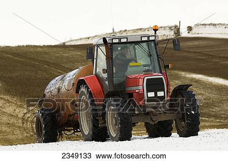 Agriculture - A tractor and slurry wagon spreading animal manure slurry fertilizer on a snow covered field in Winter / near Ravenstonedale, Cumbria, England, United Kingdom. View Large Photo Image Stock Image - Agriculture - A tractor and slurry wagon spreading animal manure slurry fertilizer on a snow covered field in Winter / near Ravenstonedale, Cumbria, England, United Kingdom.. Fotosearch