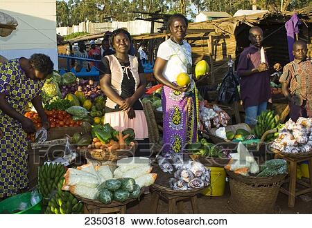 Stock Photo - Agriculture - African street traders in a market stall selling fruit and vegetables / Mumias, Kenya, Africa.. Fotosearch