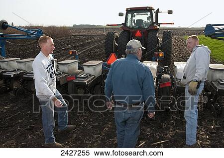 Stock Photography - Agriculture -Father and sons farmers preparing for spring planting of grain corn / near Northrop, Minnesota, USA.. Fotosearch
