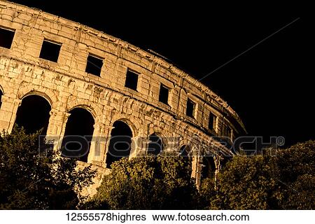 Stock Photograph - Ancient Roman Amphitheatre, known as Pula Arena, at night; Pula, Istria, Croatia. Fotosearch