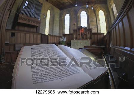 Stock Photograph - Bible open to the gospel of Matthew in a church; Blanchland, Northumberland, England. Fotosearch