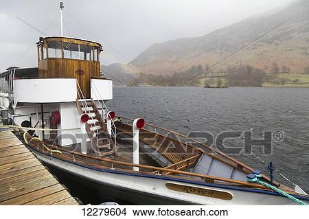 Picture - Boat moored beside a wooden dock in the fog; Cumbria, England. Fotosearch