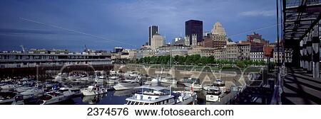 Stock Photograph - Boats fill a harbour with buildings in the background. Fotosearch