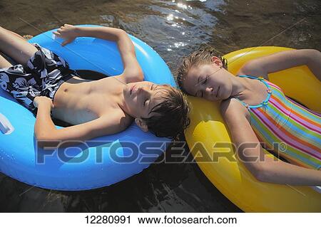 Boy and girl floating with inflatable rings on Crystal Lake; Ontario, Canada View Large Photo Image Stock Image - Boy and girl floating with inflatable rings on Crystal Lake; Ontario, Canada. Fotosearch