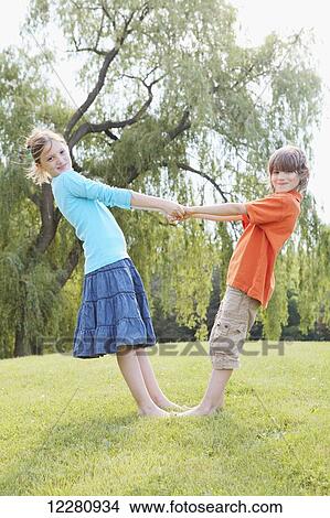 Picture - Boy and girl holding hands in park; Toronto, Ontario, Canada. Fotosearch