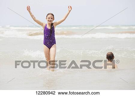 Stock Image - Boy and girl playing on beach; Grand Bend, Ontario, Canada. Fotosearch