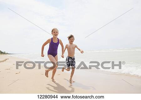 Picture - Boy and girl running on beach; Grand Bend, Ontario, Canada. Fotosearch