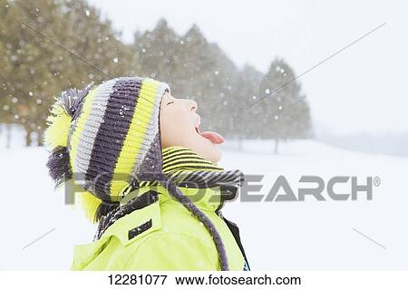 Boy catching snowflakes on her tongue; King City, Ontario, Canada View Large Photo Image Stock Photo - Boy catching snowflakes on her tongue; King City, Ontario, Canada. Fotosearch