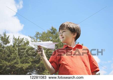 Boy holding paper airplane; King City, Ontario, Canada View Large Photo Image Stock Image - Boy holding paper airplane; King City, Ontario, Canada. Fotosearch