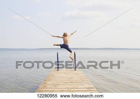 Boy jumping off end of dock on Balsam Lake; Ontario, Canada View Large Photo Image Stock Photography - Boy jumping off end of dock on Balsam Lake; Ontario, Canada. Fotosearch