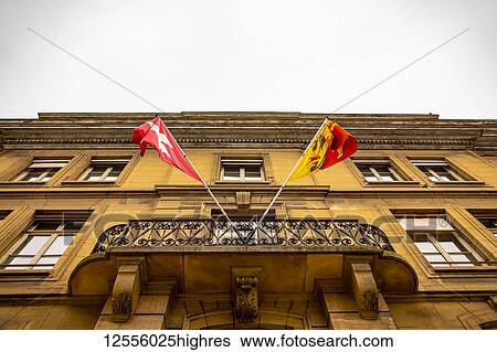 Stock Photograph - Building facade and balcony with flags of Switzerland and Geneva; Geneva, Geneva, Switzerland. Fotosearch