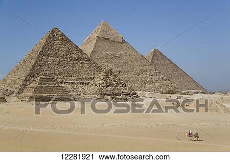 Stock Image - Camels with tourist and guide, The Giza Pyramids; Giza, Egypt. Fotosearch
