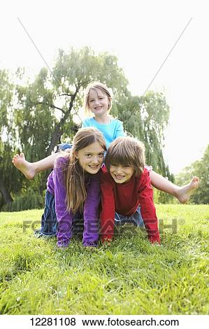 Children in a park making a human pyramid; Toronto, Ontario, Canada View Large Photo Image Stock Photo - Children in a park making a human pyramid; Toronto, Ontario, Canada. Fotosearch