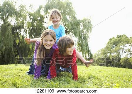 Stock Photo - Children in a park making a human pyramid; Toronto, Ontario, Canada. Fotosearch