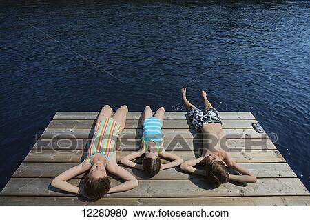 Children laying down at end of dock on Crystal Lake; Ontario, Canada View Large Photo Image Stock Image - Children laying down at end of dock on Crystal Lake; Ontario, Canada. Fotosearch